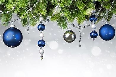 Blaue Weihnachtskugeln hängen an Tannenzweigen